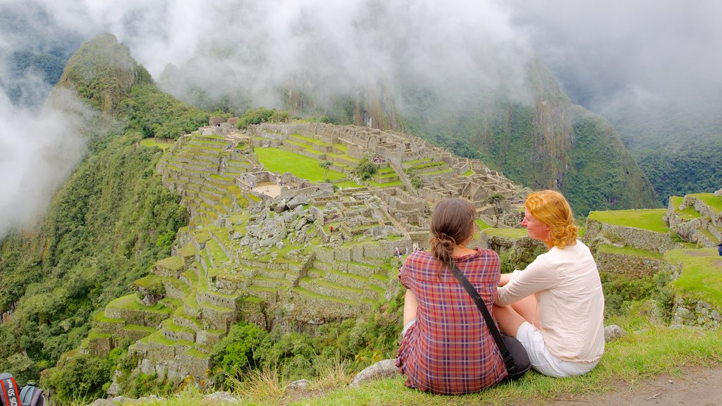 Machu Picchu ofreciendo vistas de paisajes y también un pequeño grupo de personas