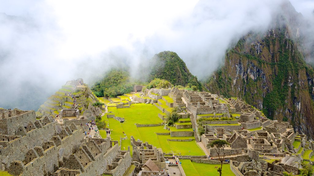 Machu Picchu mostrando ruinas de un edificio y niebla o neblina