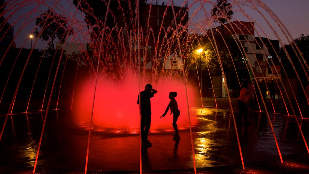 Exposition Park featuring a fountain as well as a small group of people