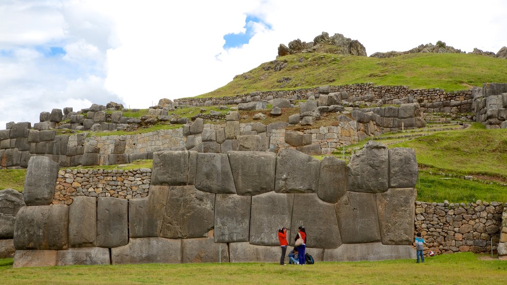 Sacsayhuaman featuring a ruin and heritage elements as well as a small group of people