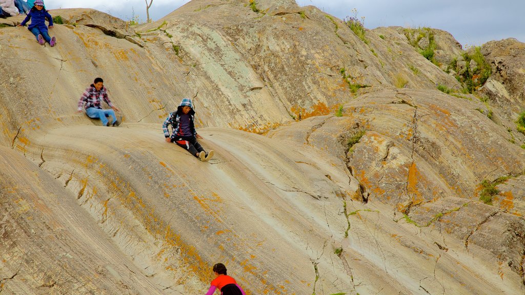 Sacsayhuamán mostrando montañas y también un pequeño grupo de personas