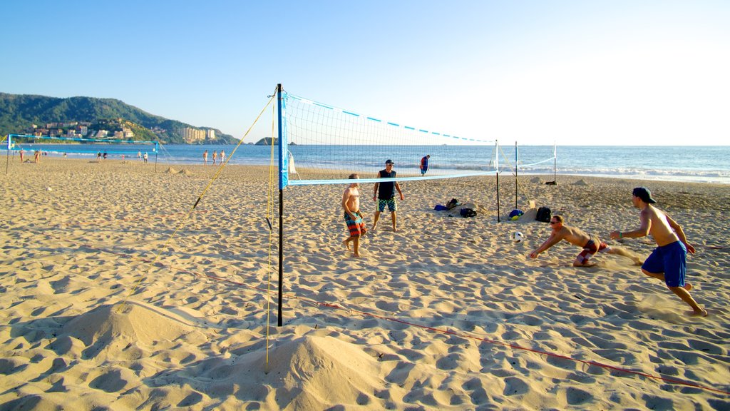 Playa de El Palmar que incluye una playa de arena y vistas generales de la costa y también un pequeño grupo de personas