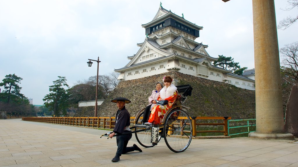 Castelo de Kokura mostrando um pequeno castelo ou palácio e cenas de rua assim como um pequeno grupo de pessoas