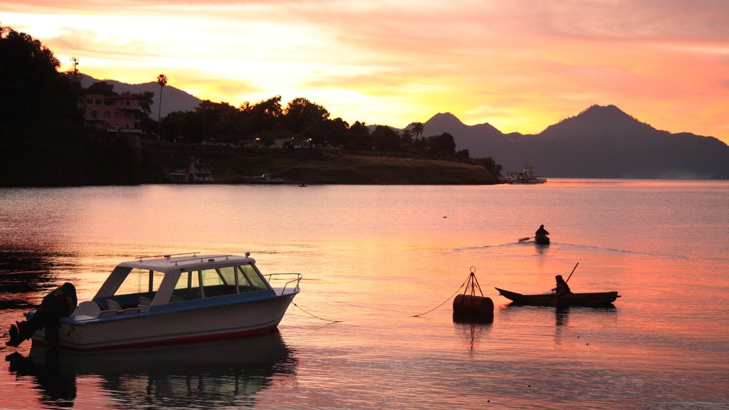 Lake Atitlan featuring landscape views, kayaking or canoeing and a sunset