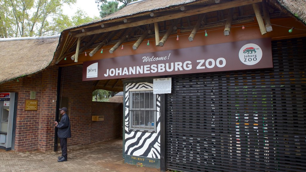 Zoológico de Joanesburgo que inclui sinalização e animais de zoológico assim como um homem sozinho