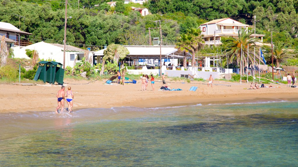 Pelekas Beach showing a coastal town, a sandy beach and swimming