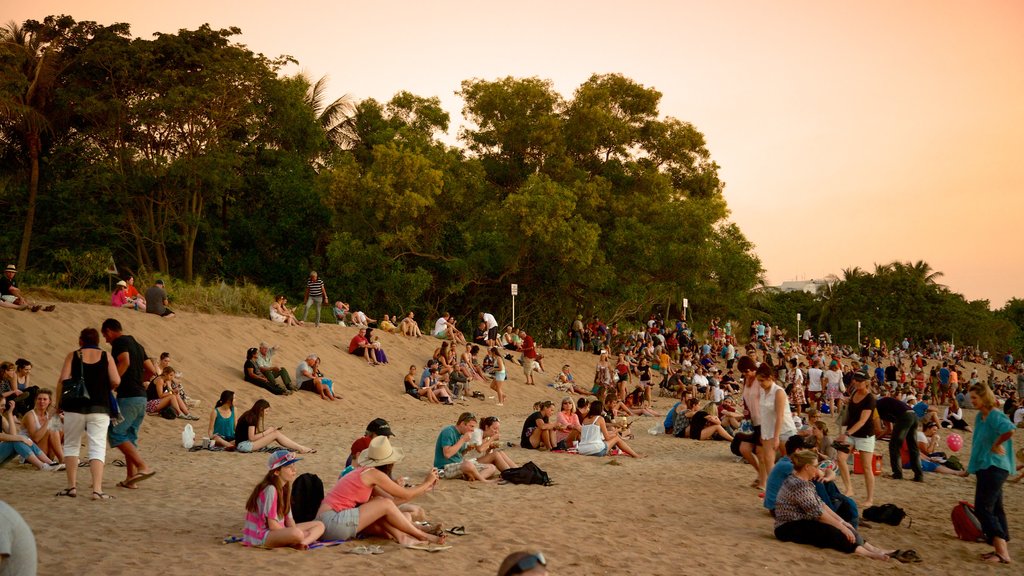 Mindil Beach which includes a sunset and a sandy beach as well as a large group of people