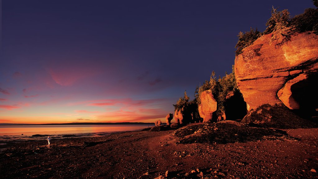 New Brunswick som visar en stenstrand och en solnedgång