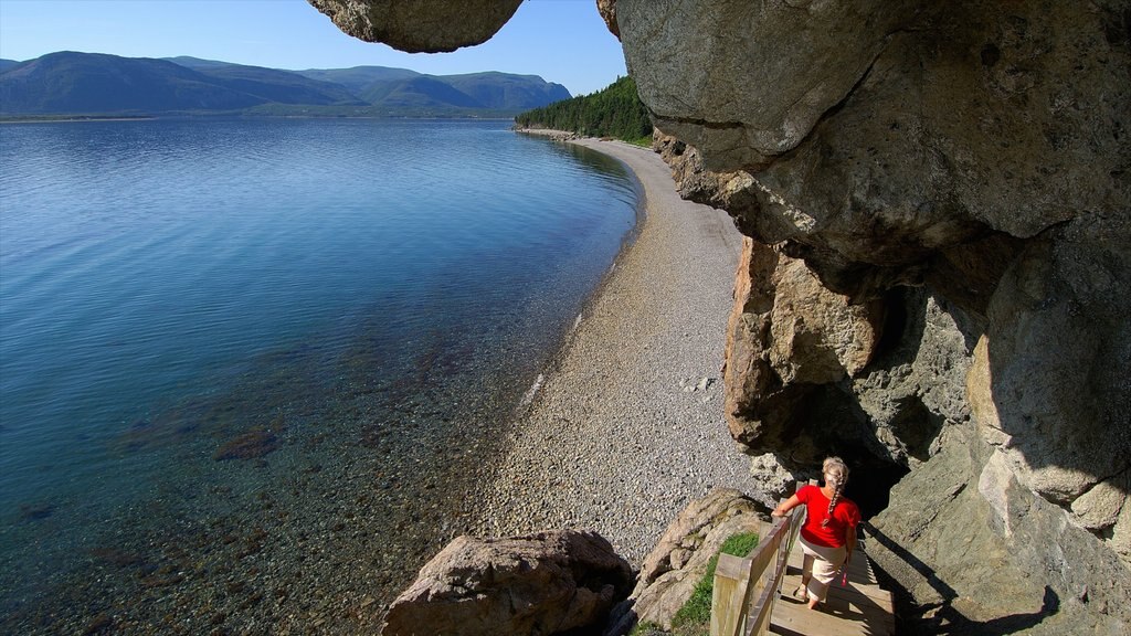 Terra Nova e Labrador caracterizando uma praia de pedras assim como uma mulher sozinha