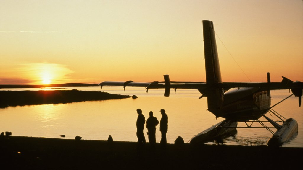 Nunavut mostrando aeronave e um pôr do sol assim como um pequeno grupo de pessoas