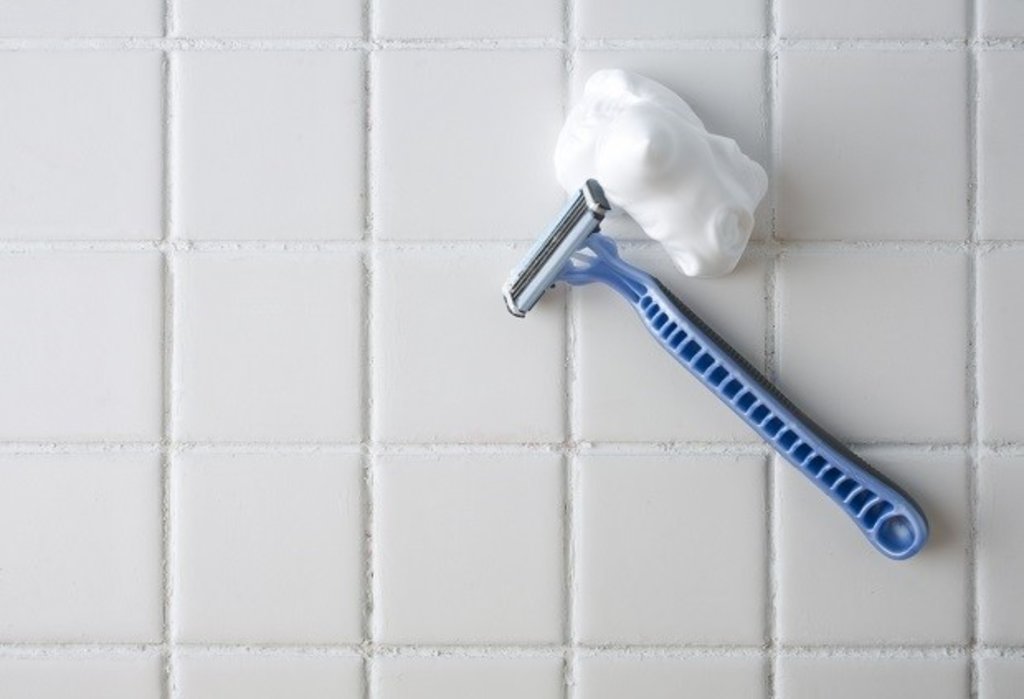 Razor and shaving foam in bathroom
