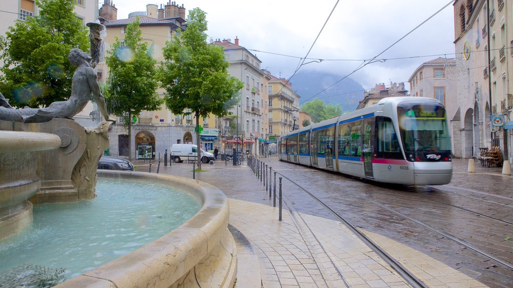 Place Notre Dame que incluye artículos ferroviarios, una fuente y imágenes de calles