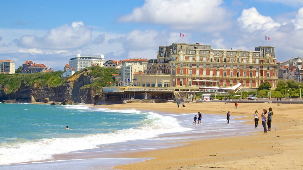 Grand Beach which includes a coastal town and a sandy beach