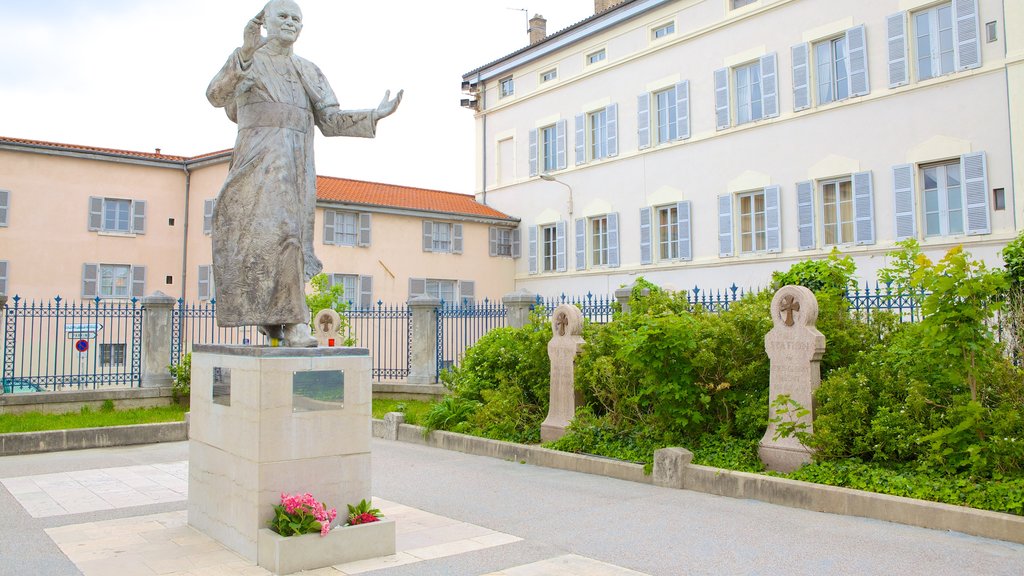 Basílica de Notre-Dame caracterizando uma estátua ou escultura e uma praça ou plaza