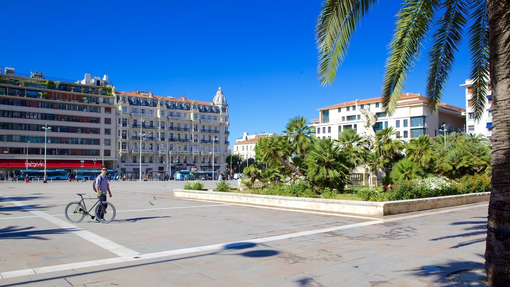 Place de la Liberte showing a square or plaza and cycling as well as an individual male