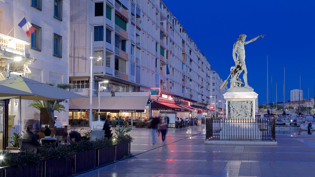 Toulon Marina which includes a square or plaza, night scenes and a statue or sculpture