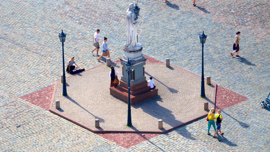 Iglesia de San Pedro que incluye una estatua o escultura y un parque o plaza y también un gran grupo de personas