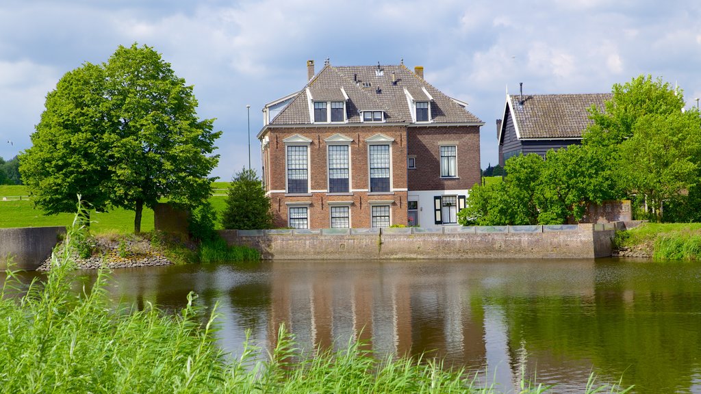 Kinderdijk que inclui uma casa e um rio ou córrego