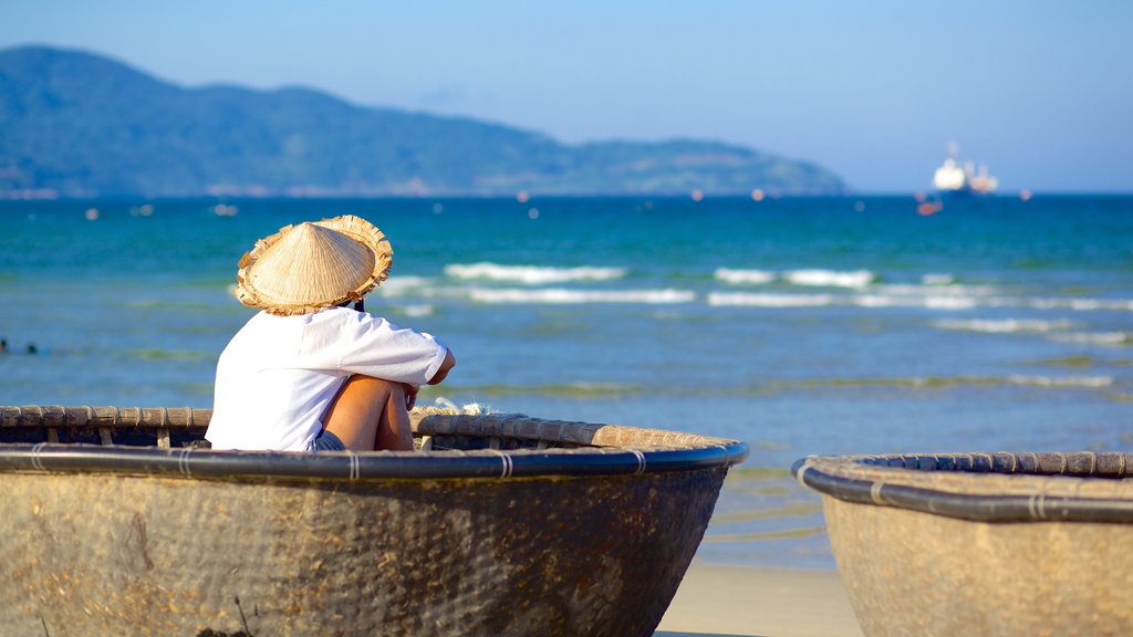 My Khe Beach showing boating and a sandy beach as well as an individual male