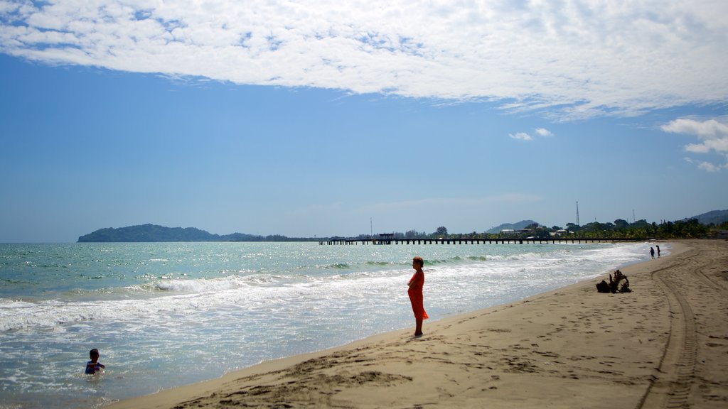 Tela showing a sandy beach and swimming as well as a small group of people