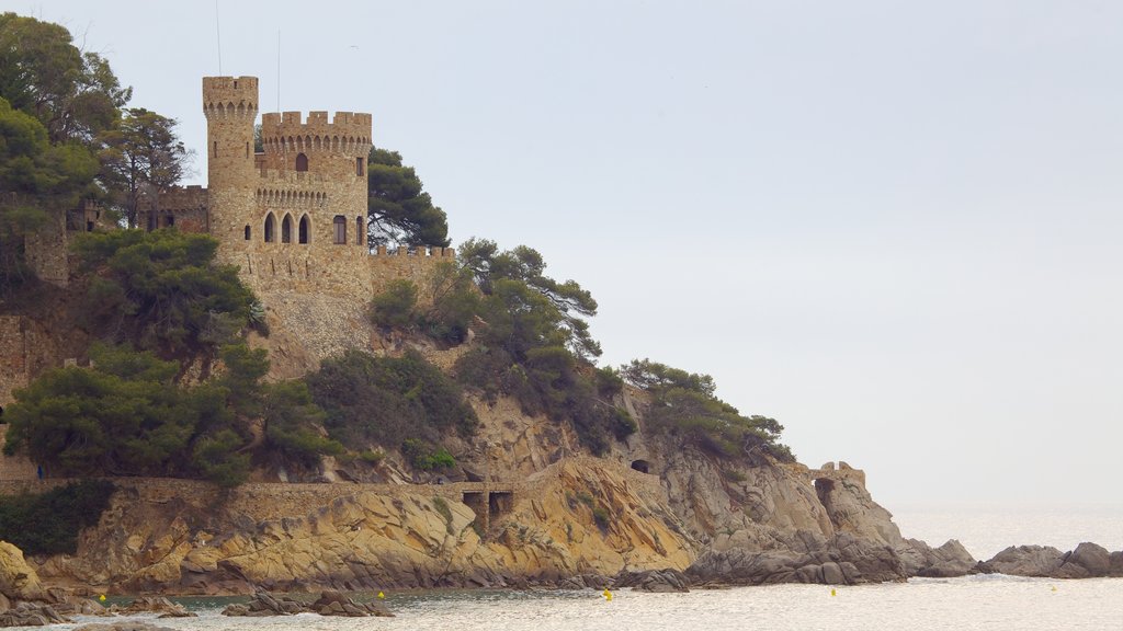 Playa de Lloret de Mar ofreciendo un castillo y costa escarpada