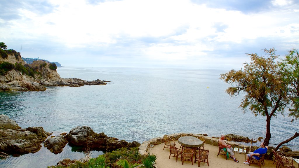 Castelo de Sant Joan mostrando litoral rochoso e jantar ao ar livre assim como um pequeno grupo de pessoas