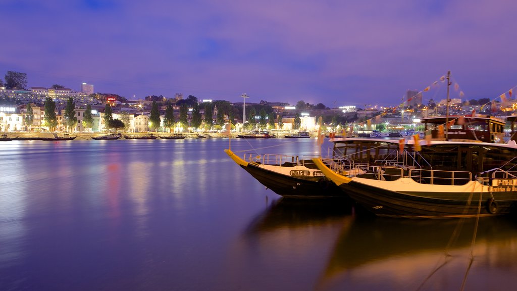 Puente Dom Luis I mostrando paseos en lancha, escenas nocturnas y una ciudad costera