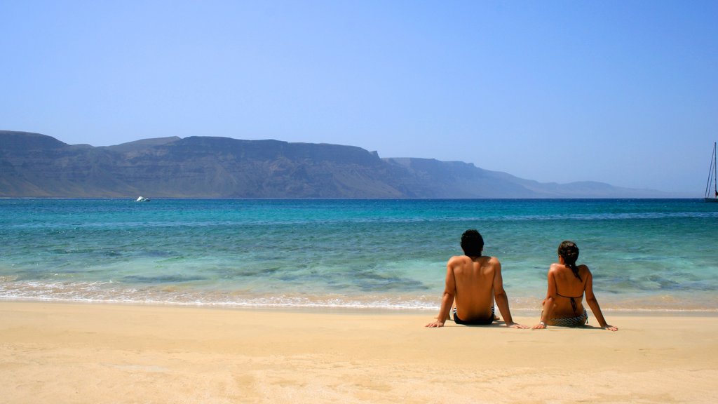 Lanzarote showing a sandy beach as well as a couple