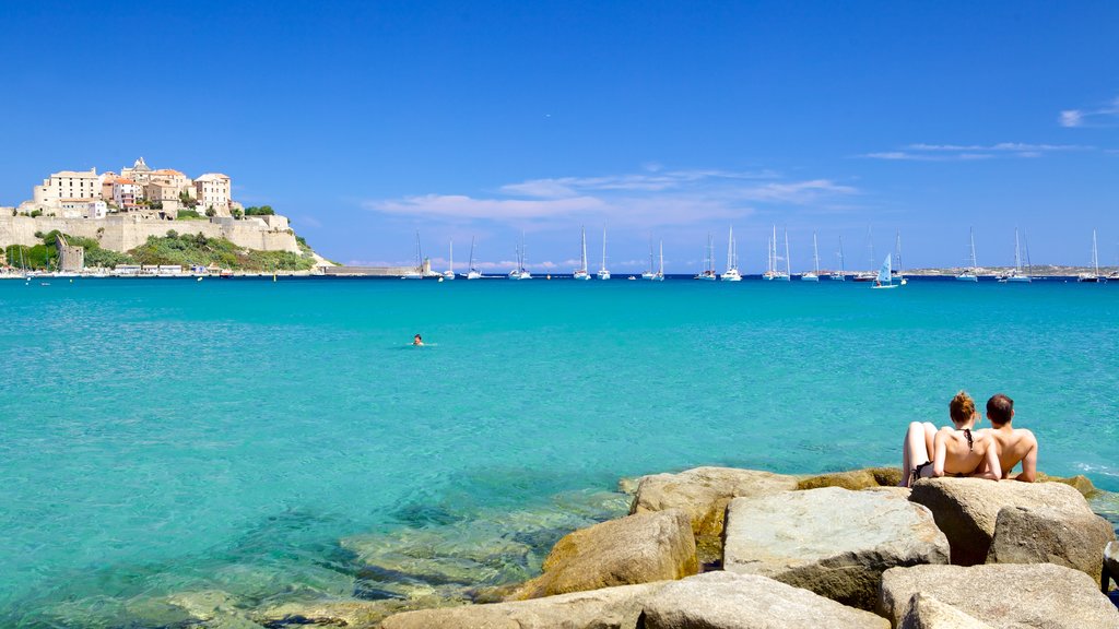 Calvi-stranden som viser en kystby og udsigt over kystområde såvel som et par