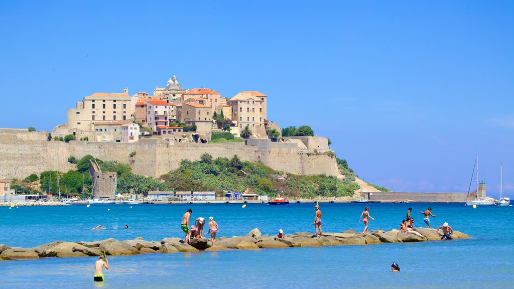 Calvi Beach showing heritage architecture and rocky coastline