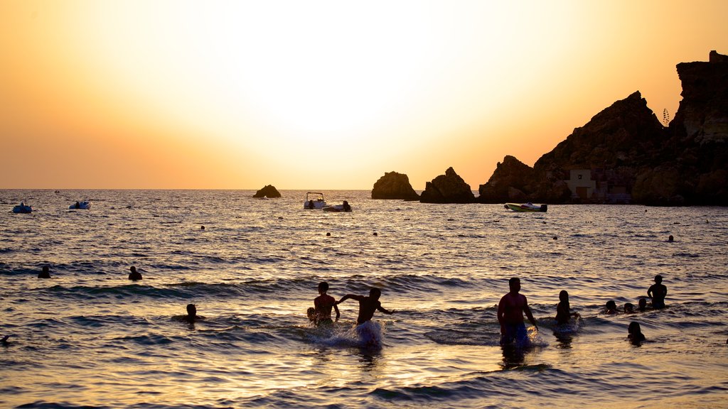 Golden Sands Beach which includes swimming, general coastal views and a sunset