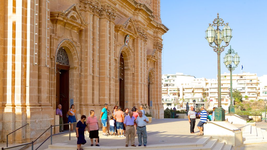 Iglesia de Mellieha mostrando una iglesia o catedral, elementos religiosos y una ciudad