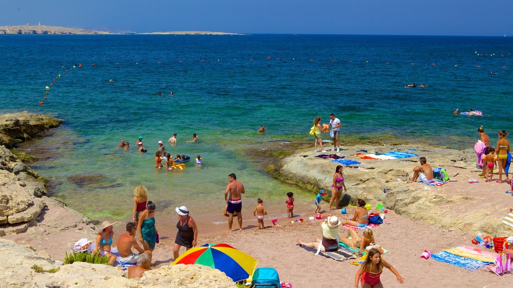 Bugibba Beach showing a sandy beach as well as a large group of people