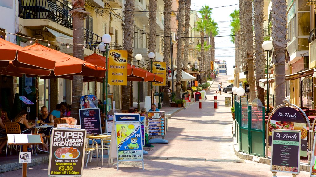 Bugibba Beach featuring outdoor eating, café lifestyle and signage