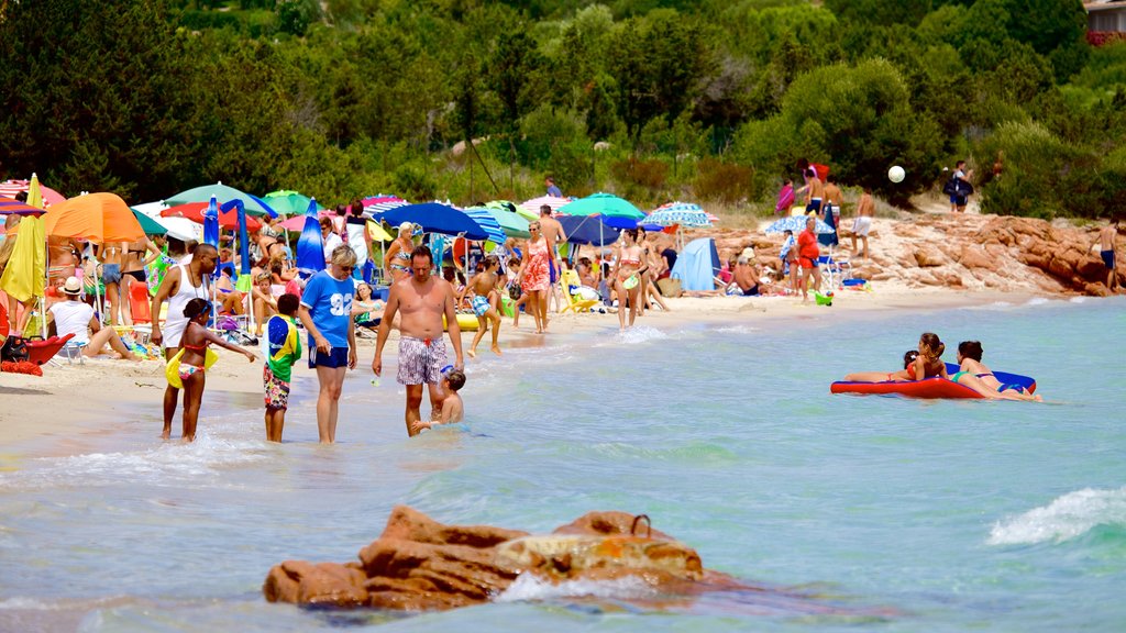 Porto Istana showing a beach as well as a large group of people