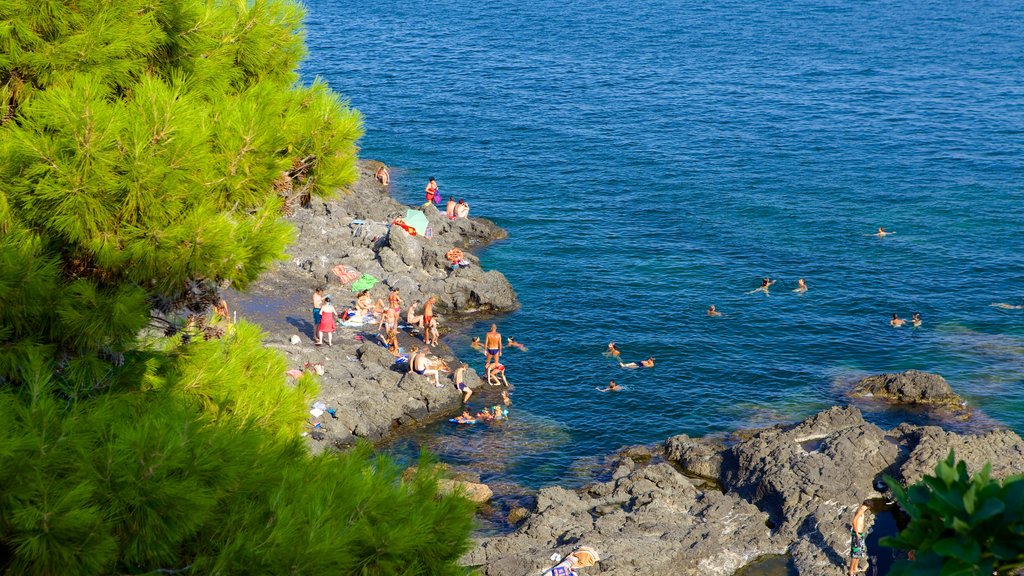 Aci Castello mostrando costa escarpada y natación