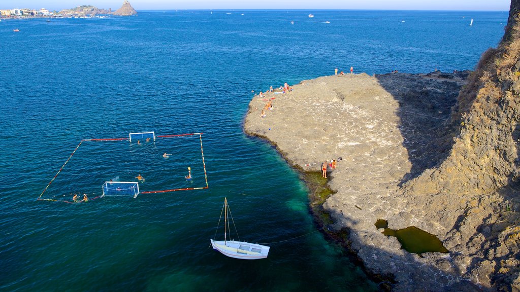 Aci Castello showing rocky coastline and watersports