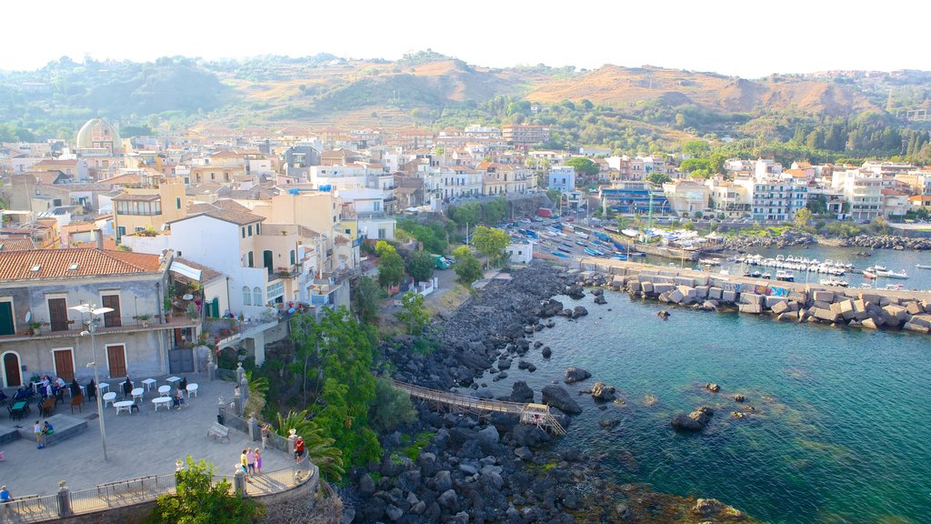 Aci Castello mostrando costa rocosa y una ciudad costera