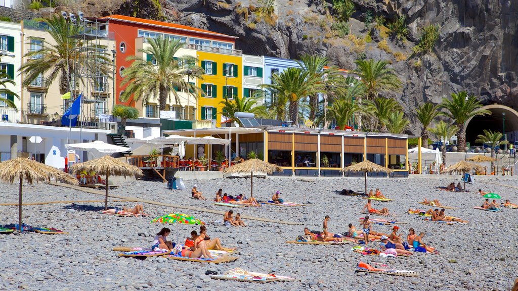 Ponta Do Sol Strand som viser en stenstrand, en kystby og tropiske områder