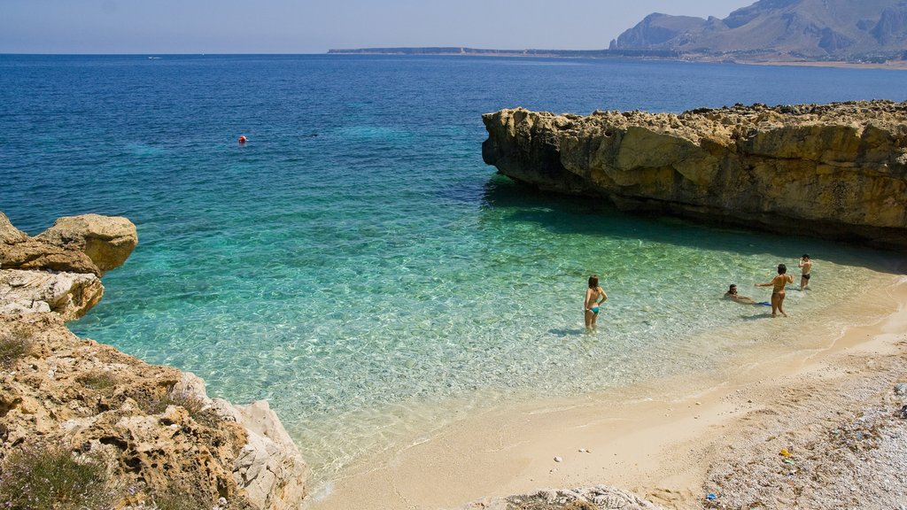 San Vito Lo Capo showing a sandy beach and swimming as well as a small group of people