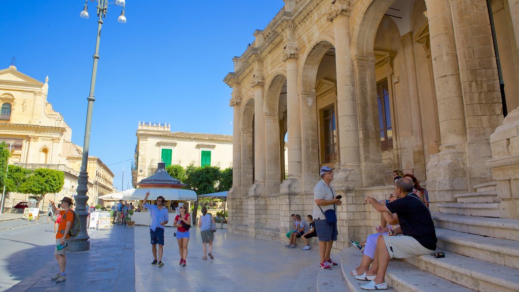 Ducezio Palace showing heritage elements and street scenes as well as a large group of people