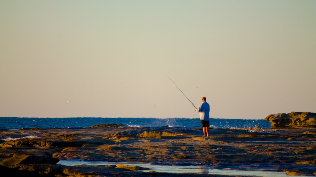 Shelly Beach caracterizando pesca e paisagens litorâneas assim como um homem sozinho