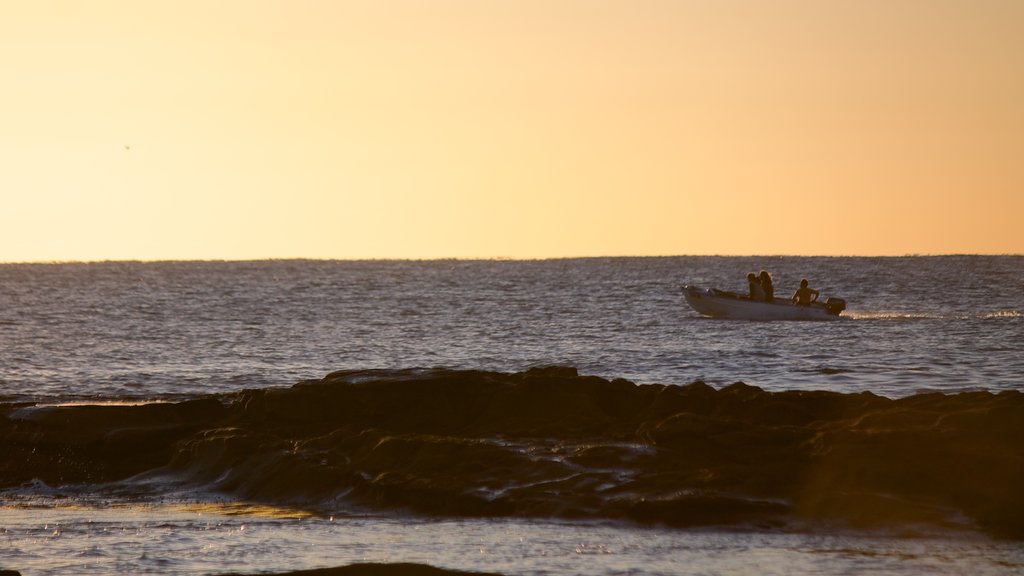 Shelly Beach que incluye un atardecer, botes y vista general a la costa