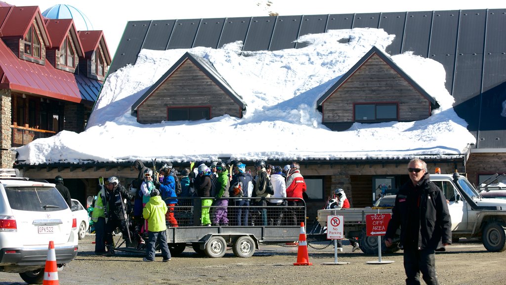 Cardrona Alpine Resort caracterizando neve assim como um pequeno grupo de pessoas