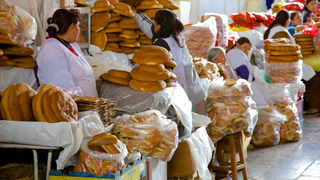 Mercado de San Pedro de Cusco mostrando comida y mercados y también un pequeño grupo de personas