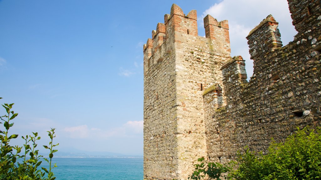 Castillo de Scaliger ofreciendo ruinas de edificios, elementos del patrimonio y un lago o abrevadero