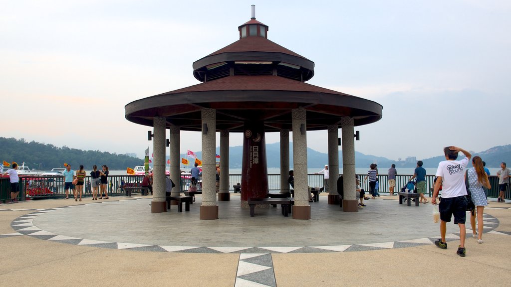 Sun Moon Lake showing a lake or waterhole as well as a small group of people