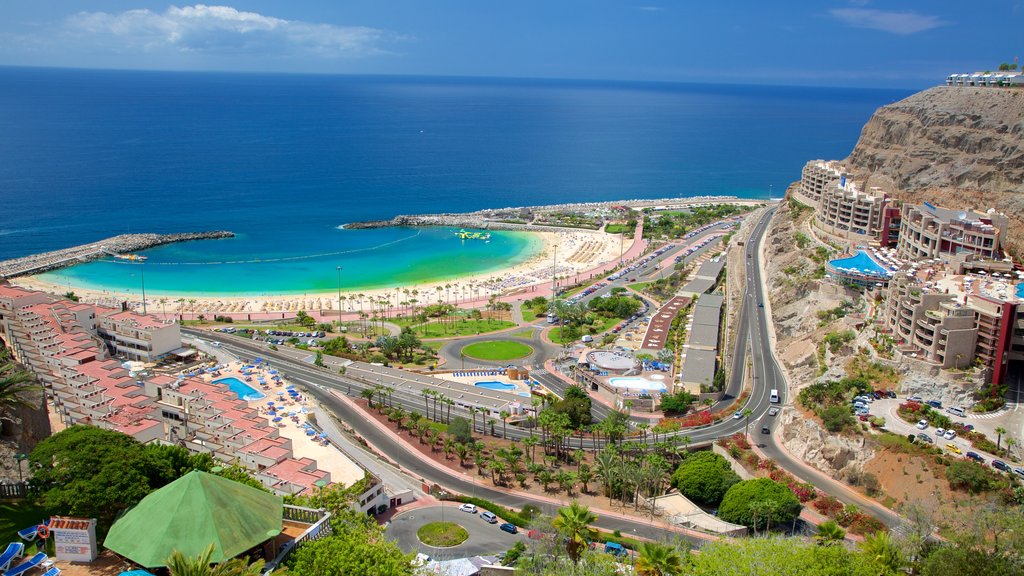 Playa de Amadores ofreciendo una ciudad, una playa de arena y vista general a la costa