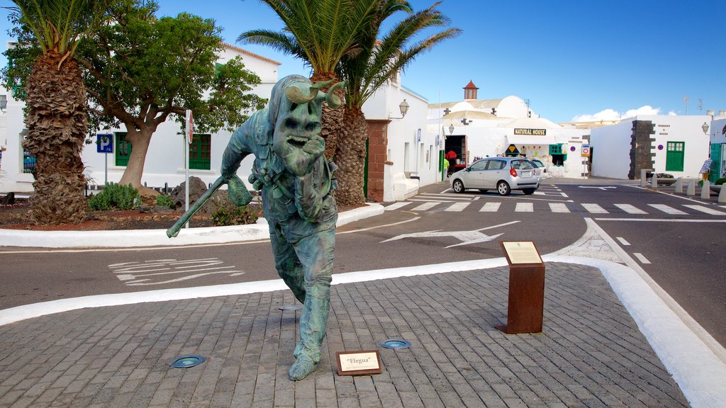 Teguise ofreciendo una ciudad y una estatua o escultura