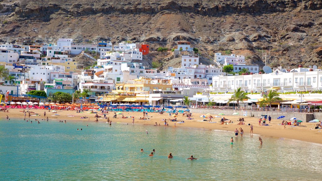 Playa de Mogan which includes a beach, a coastal town and general coastal views